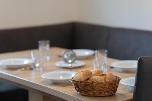 a wooden table with a basket of bread on it at Ferienhaus Knechtsand 09 in Dorum Neufeld