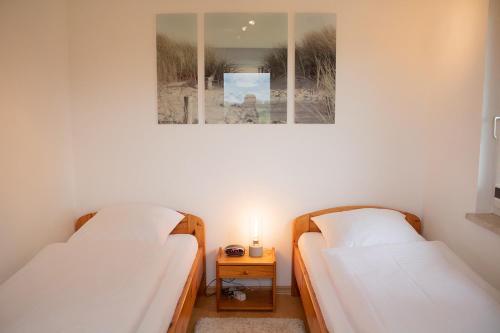 two beds in a room with a picture on the wall at Ferienhaus Kiebitzmoor 7 in Bad Bederkesa