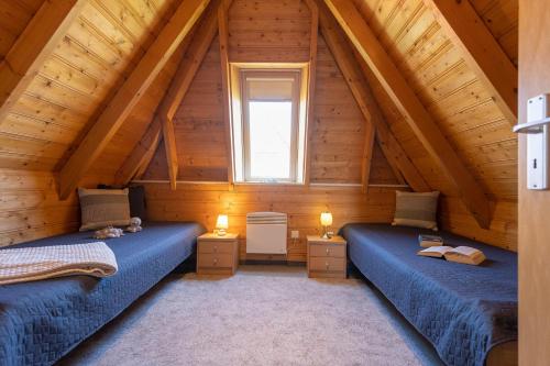 a bedroom with two beds in a wooden attic at Ferienhaus Hans Albers 16 in Wremen