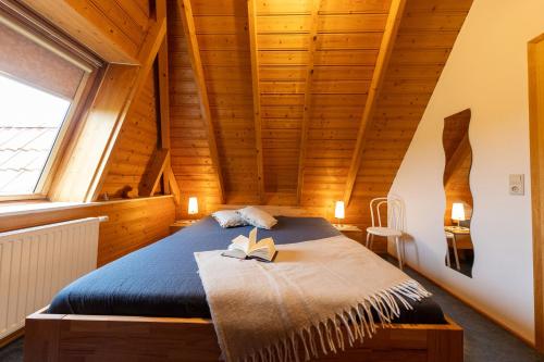 a bedroom with a bed with a book on it at Ferienhaus "Heinemann" Lale Andersen 19 in Wremen