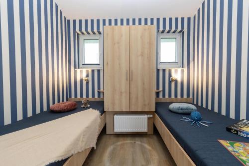 two beds in a room with blue and white stripes at Ferienhaus Mellumplate 04 in Dorum Neufeld