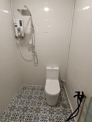 a small bathroom with a shower and a toilet at Alameen Boutique Hotel in Kangar
