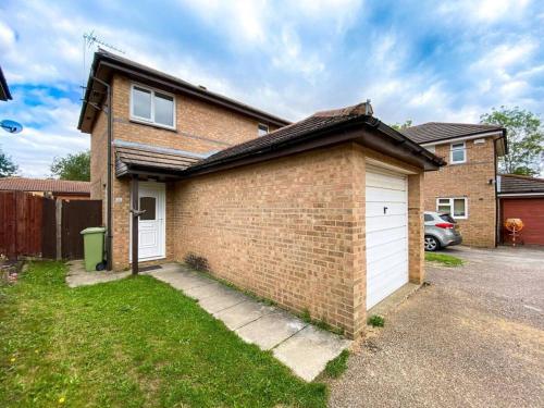a brick house with a white garage at Quiet Location next to CMK in Milton Keynes