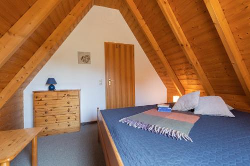 ein Schlafzimmer mit einem blauen Bett und einer Holzdecke in der Unterkunft Ferienhaus Westertill 03 in Dorum Neufeld