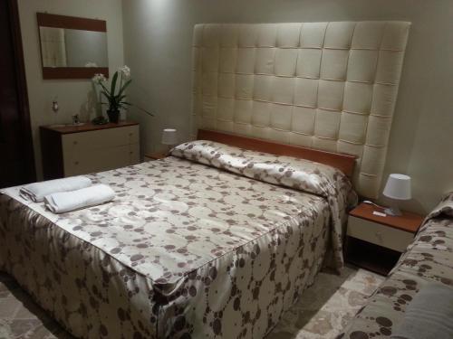 a bedroom with a large bed with a large headboard at B&B Panoramic in Valguarnera Caropepe
