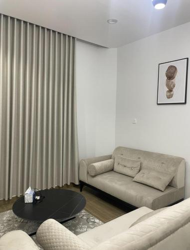 a living room with a couch and a table at استديو هادئ وأنيق مدخل مستقل in Hail