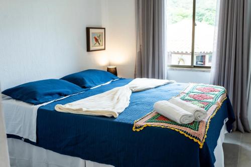 a blue bed with blue pillows and towels on it at Pousada do Lago in Guaramiranga