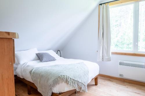 a white bedroom with a bed and a window at Le Relais des Hautes Gorges in Saint Aime Des Lacs