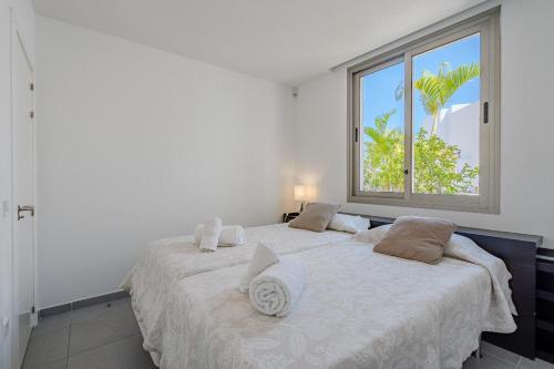 1 dormitorio con 2 camas y ventana grande en Villa Caterina, Luxury Villa with Heated Pool Ocean View in Adeje, Tenerife, en Adeje
