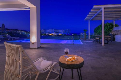 a table with a glass of wine on a patio at night at Villa Krini Delight in vlicha