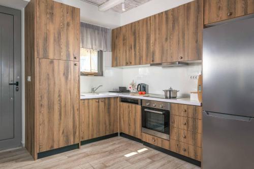 a kitchen with wooden cabinets and a stainless steel refrigerator at Villa Krini Delight in vlicha