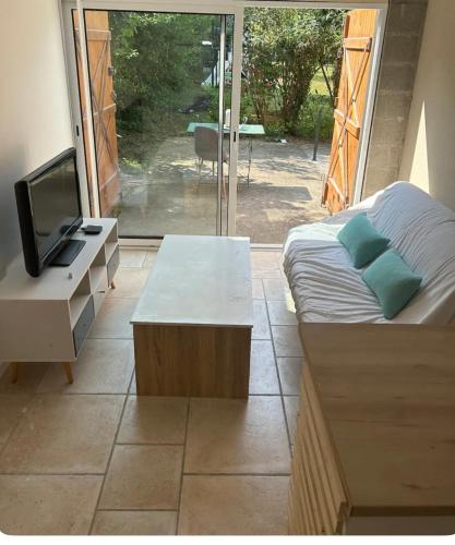 une chambre avec un lit, une télévision et une table dans l'établissement Appartement duplex avec terrasse, à Grez-sur-Loing
