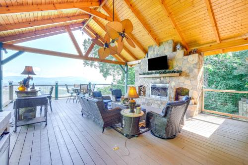 a screened in porch with a stone fireplace and furniture at Hiawassee Home with Fire Pit and Furnished Deck! in Hiawassee