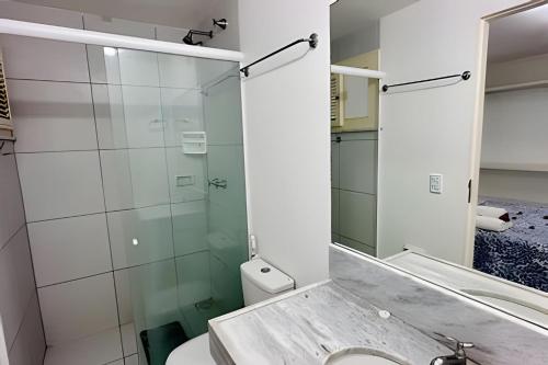 a bathroom with a glass shower and a toilet at Bouganville Apartments in Flecheiras