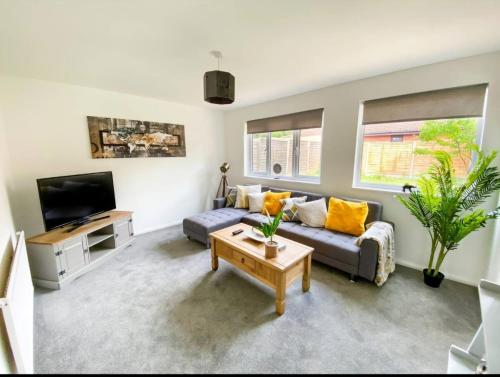a living room with a couch and a tv at Quiet Location next to CMK in Milton Keynes