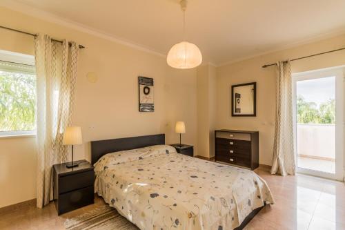 a bedroom with a bed and a large window at Villa V5 Alvor in Alvor
