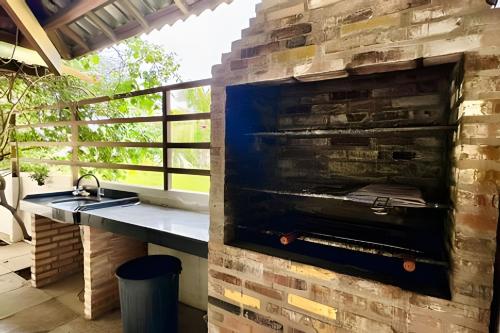 a brick oven in a kitchen with a sink at Bouganville Apartments in Flecheiras