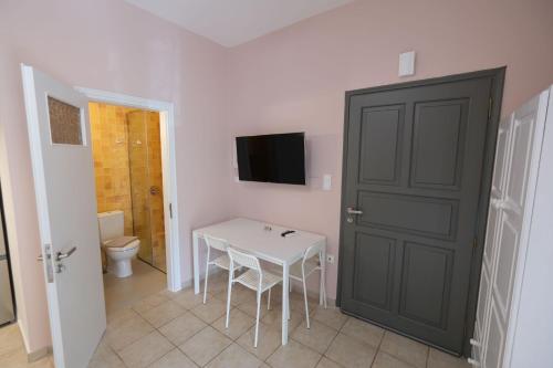 a room with a table and a toilet and a door at Central Apartments in Kardamili