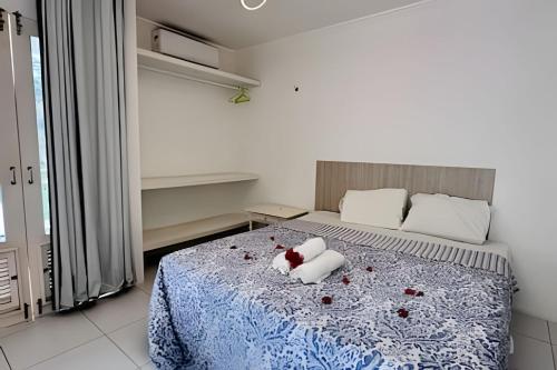 a bedroom with a bed with a teddy bear on it at Bouganville Apartments in Flecheiras