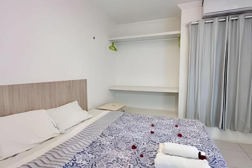 a bedroom with a bed with a blue and white blanket at Bouganville Apartments in Flecheiras