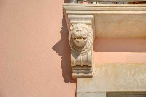 a statue of a lion on the side of a building at Veranda Syros House in Ermoupoli