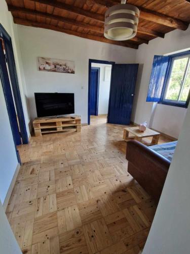 a living room with wooden floors and a fireplace at Casa dos Martelitos in Santiago de Montalegre