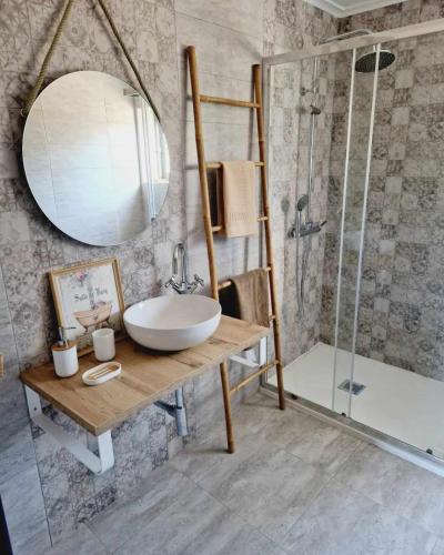 a bathroom with a sink and a shower and a mirror at Casa dos Martelitos in Santiago de Montalegre