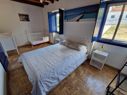 a bedroom with a bed and a large window at Casa dos Martelitos in Santiago de Montalegre