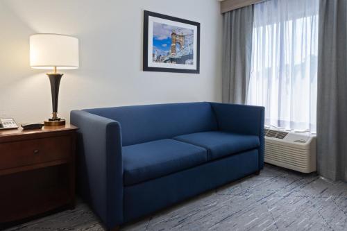 a blue couch in a room with a window at Holiday Inn Express & Suites Cincinnati Riverfront by IHG in Covington