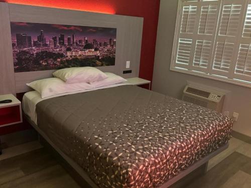 a bedroom with a bed with a large poster of a city at Playa Inn Motel - Long Beach, LA in Long Beach