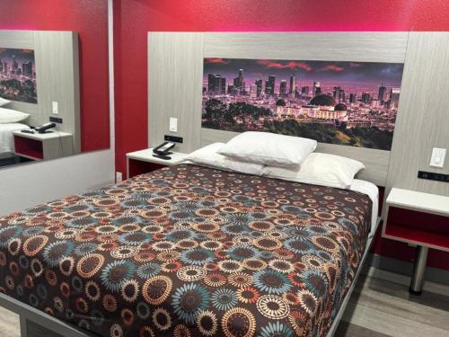 a bedroom with a bed with a painting on the wall at Playa Inn Motel - Long Beach, LA in Long Beach