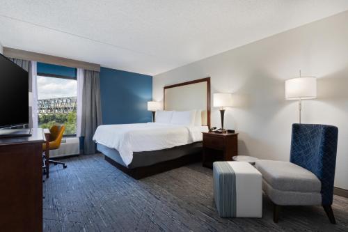 a hotel room with a bed and a large window at Holiday Inn Express & Suites Cincinnati Riverfront by IHG in Covington