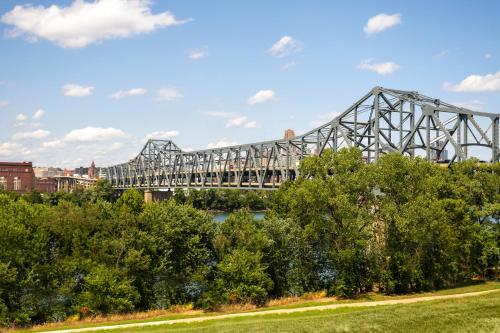 a bridge over a river with trees in the foreground at Holiday Inn Express & Suites Cincinnati Riverfront by IHG in Covington
