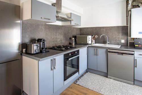 une cuisine avec des armoires blanches et un four à plaques de cuisson dans l'établissement Appartement entier - Centre historique, à Angoulême