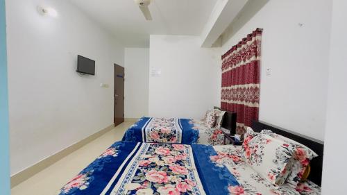 a bedroom with a bed with a blue comforter at Mohammadia Restaurant & Guest House in Dhaka