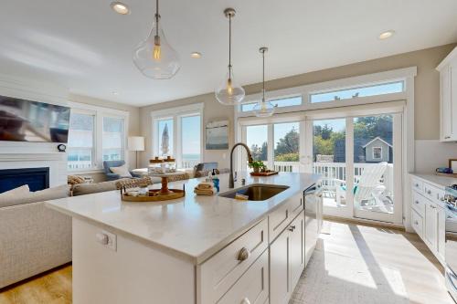 a kitchen with a sink and a living room at Pacific Breeze in Lincoln City