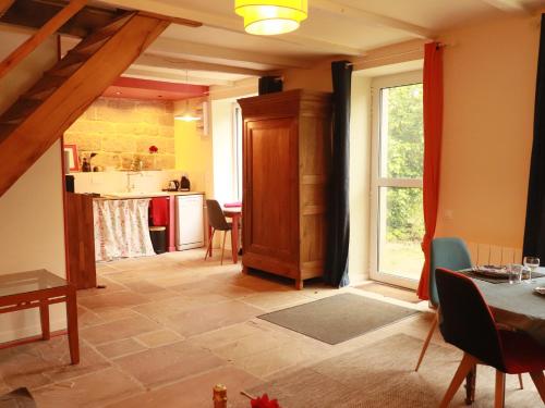a living room with a table and a kitchen at Gîte de LEIGNOUA in Le Saint