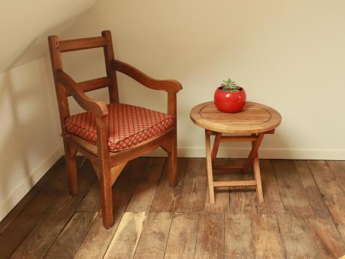 a chair and a table with a red apple on it at Gîte de LEIGNOUA in Le Saint