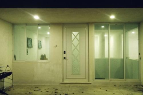 an empty room with a door and glass walls at Casa Sótano, con alberca in Las Delicias