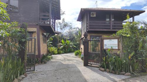 a gate to a house with a sign in front of it at Pousada Zululand in Guarda do Embaú