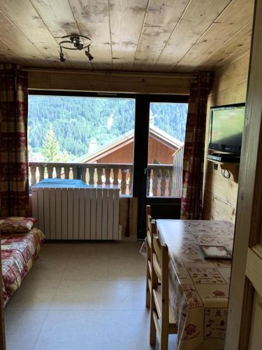 Cette chambre dispose d'une table et d'un balcon avec vue. dans l'établissement Résidence BruyÈres - Les Hauts De Planchamp - Studio pour 3 Personnes MAE-3349, à Champagny-en-Vanoise
