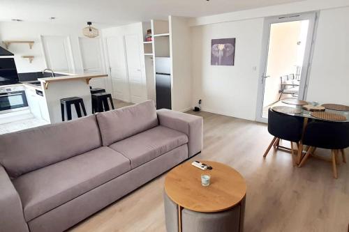 un salon avec un canapé et une table dans l'établissement jolis logements brivistes 5, à Brive-la-Gaillarde