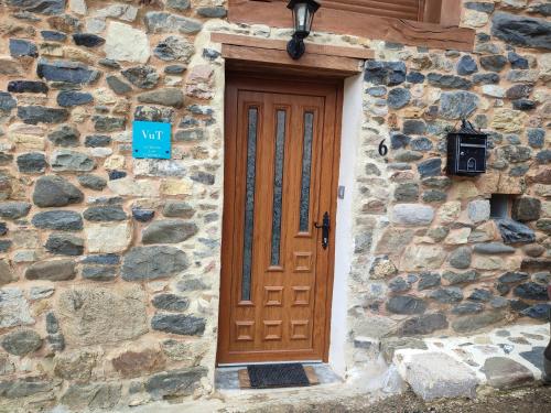 a wooden door on the side of a stone building at Casa Aires de Pajares in Camplongo