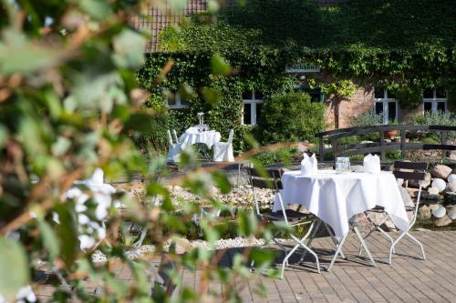 a group of tables with white table cloths at Hotel Kolonieschänke in Burg