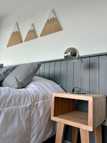 1 cama con mesa de madera junto a la cama en Penguins Flats 2, en Ushuaia