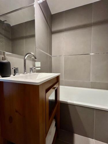 un baño con lavabo y bañera en Penguins Flats 2, en Ushuaia