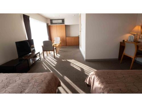 a hotel room with two beds and a desk at COCOLAND - Vacation STAY 74007v in Ube