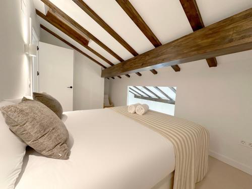 a bedroom with a white bed with pillows at Duplex con vistas a Santa María in Castro-Urdiales
