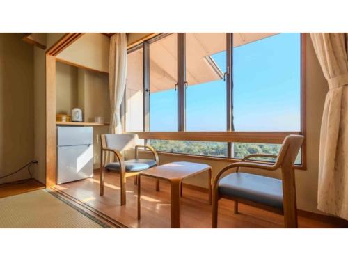 a kitchen with two chairs and a table and a window at COCOLAND - Vacation STAY 73981v in Ube