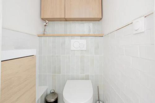 a white bathroom with a toilet and a cabinet at Charmant Appartement Cosy à Suresnes in Suresnes